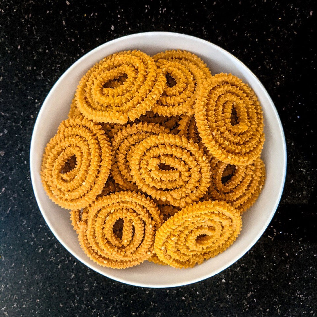 A bowl of golden spiral chakli