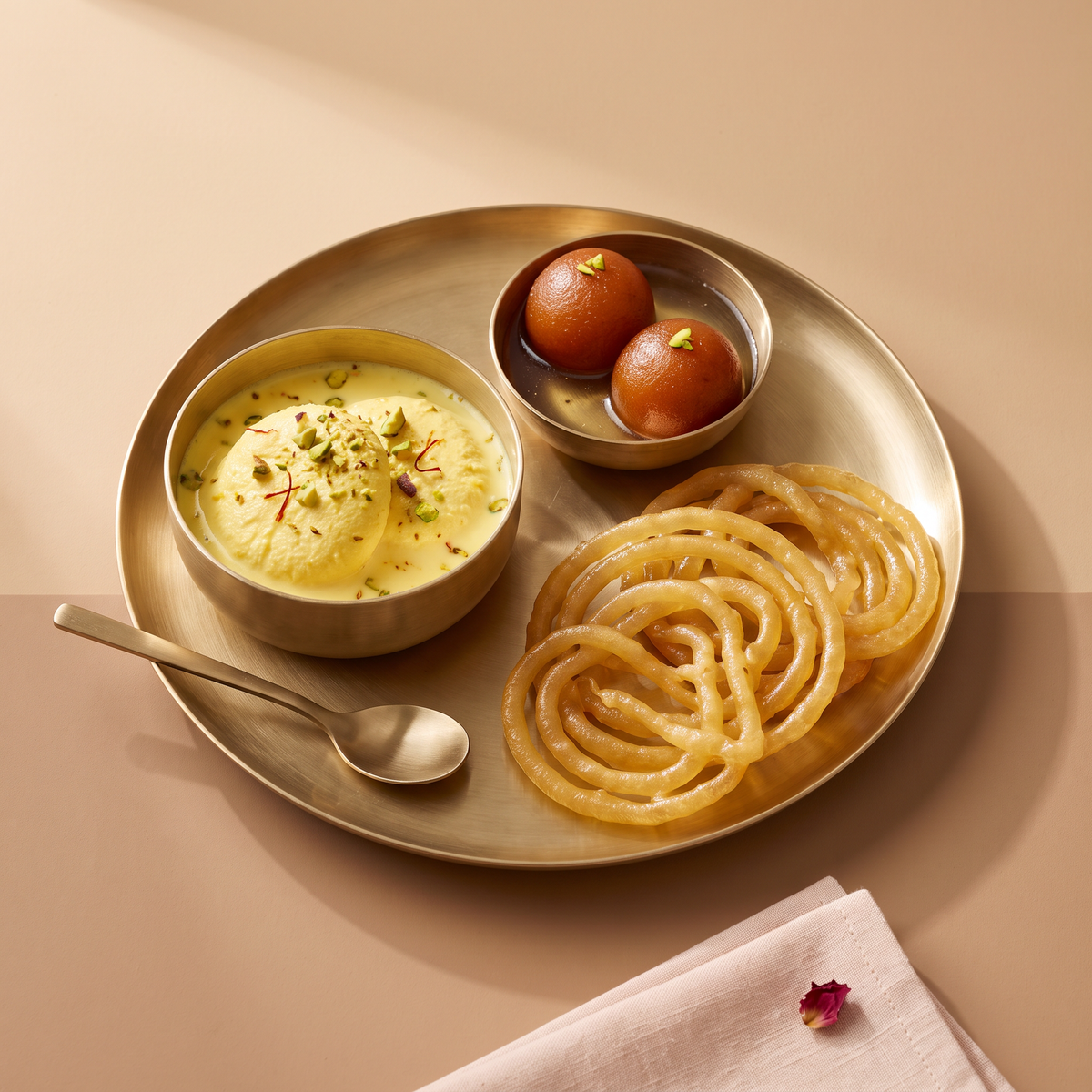 Rasmalai, gulab jamun and jalebi on a brass platter